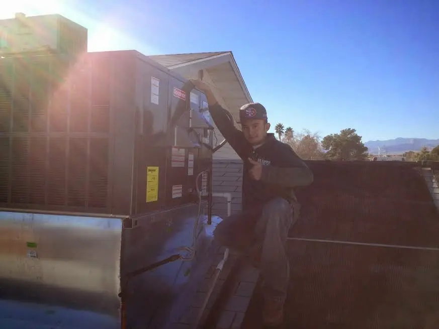 HVAC technician performing Air Duct Cleaning on a rooftop unit in Savannah